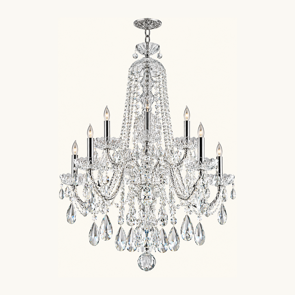 A multi-light crystal chandelier with a polished silver-tone metal frame, featuring clear hanging teardrop crystals and candle-style bulbs, shown against a solid off-white background.