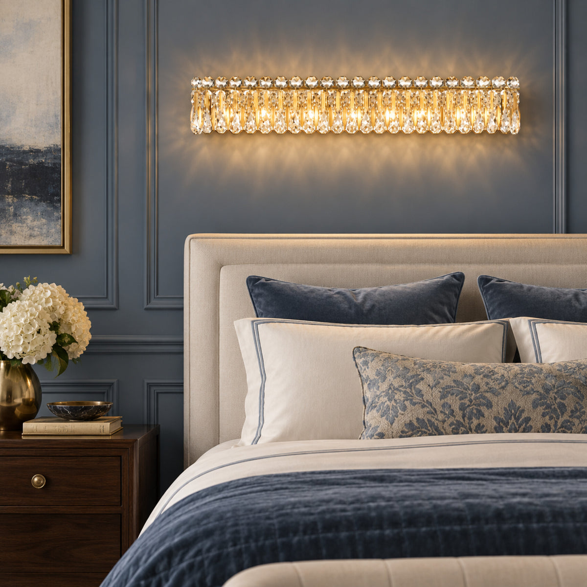 Sarella 8-light wall sconce in heirloom gold with heritage crystal displayed in a slate-blue transitional bedroom