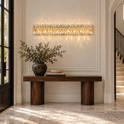 Sarella 8-light wall sconce in heirloom gold with heritage crystal displayed in a limestone European contemporary foyer
