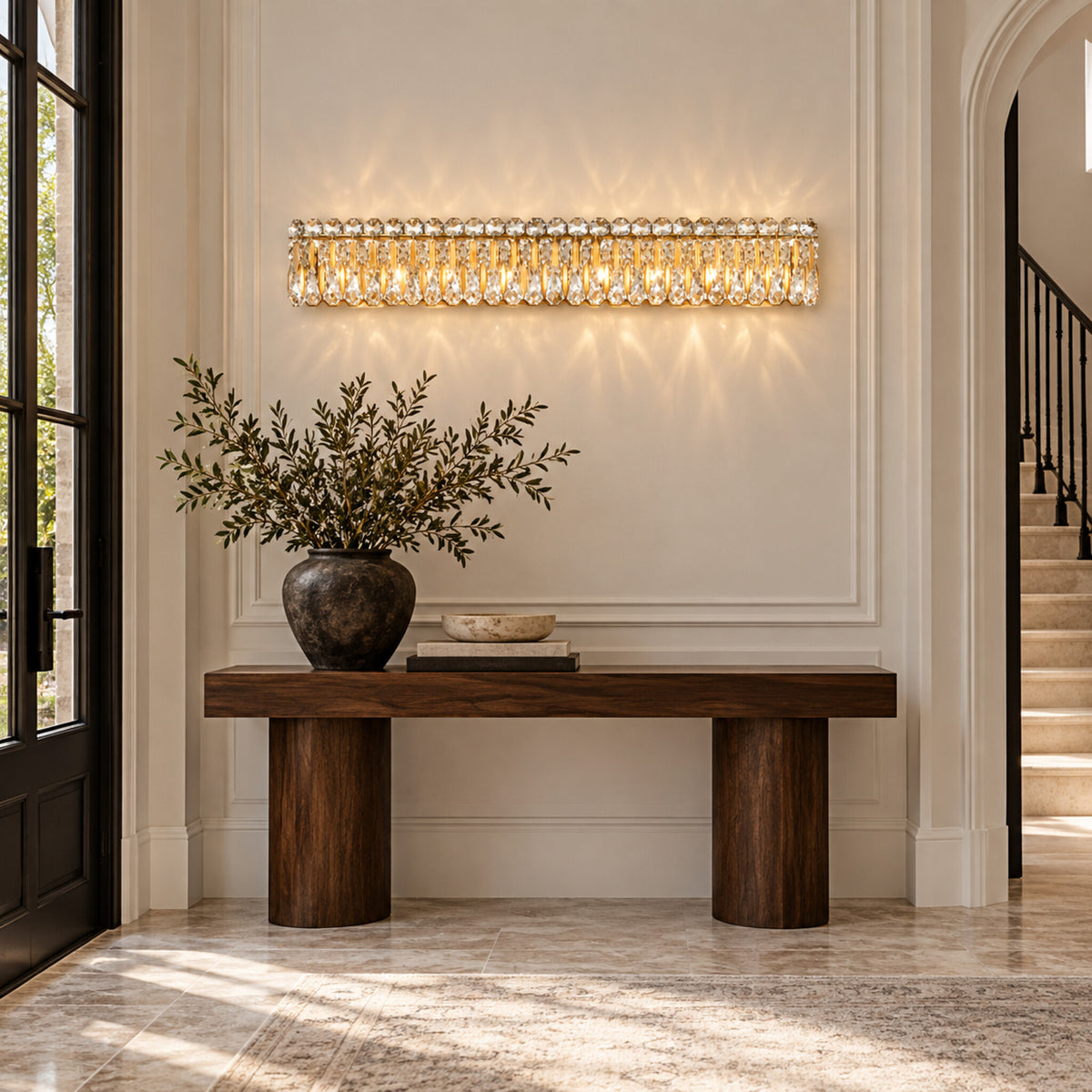 Sarella 8-light wall sconce in heirloom gold with heritage crystal displayed in a limestone European contemporary foyer